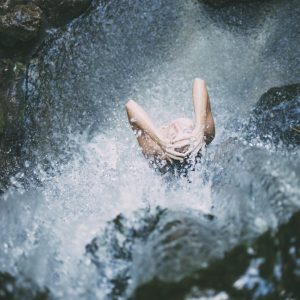 Frau unter einem Wasserfall